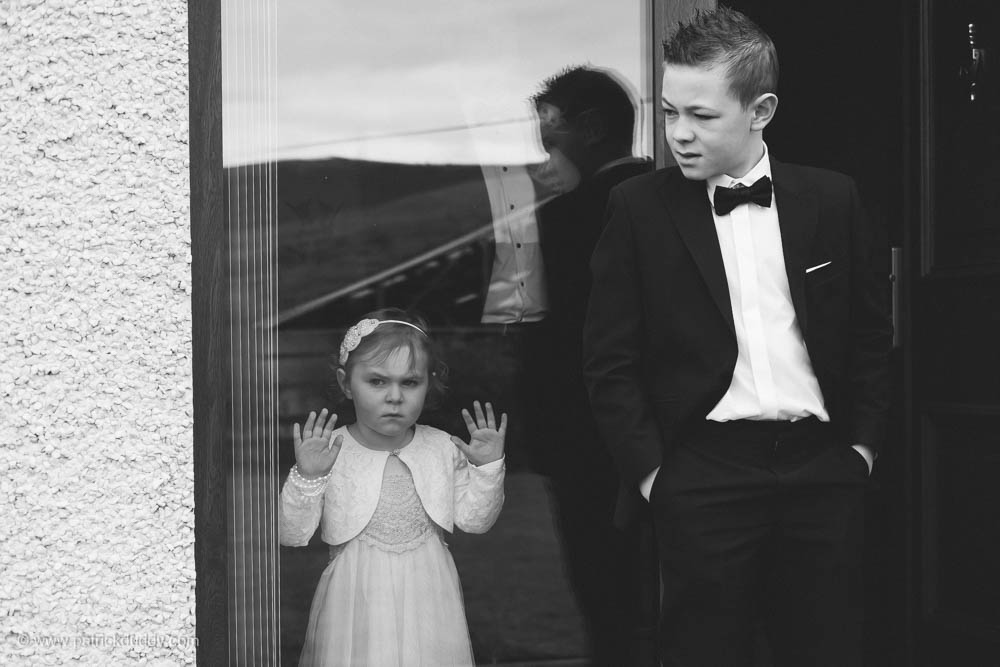 Candid doucmentary wedding photograph of flowergirl and pageboy waiting before Ballyscullion Park by Patrick Duddy Wedding Photography