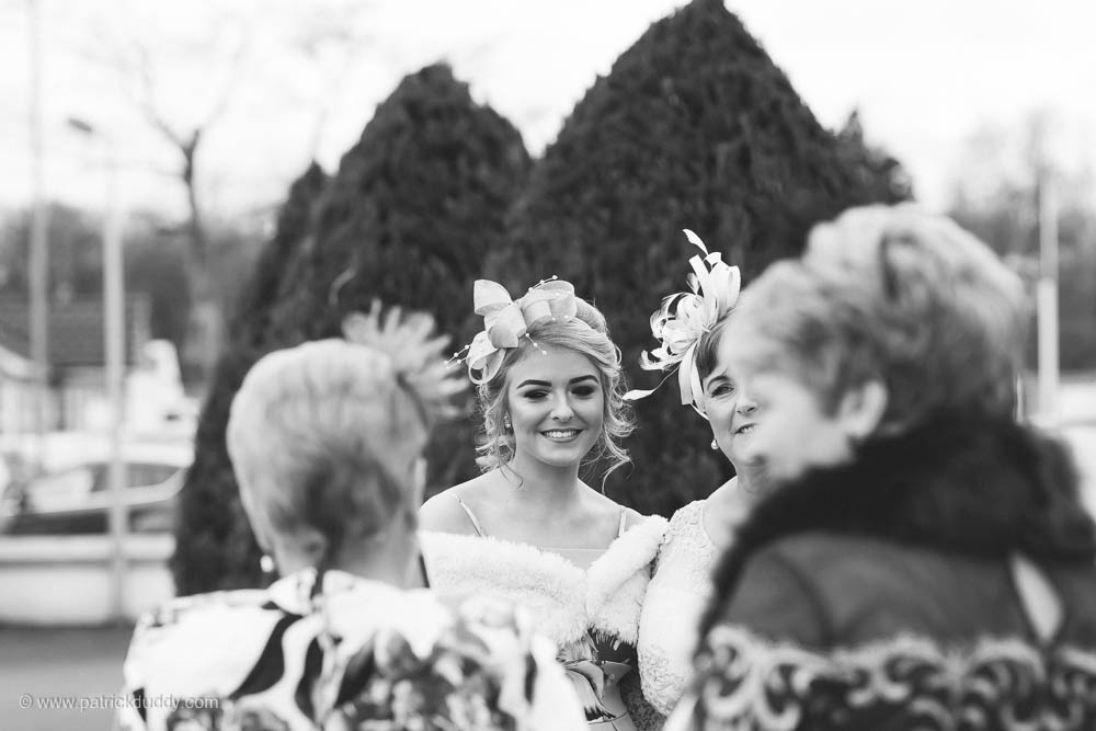 Black and white wedding photography of wedding guests after ceremony in chapel, prior to wedding at Ballyscullion Park Wedding Venue by Patrick Duddy Documentary Candid Wedding Photography