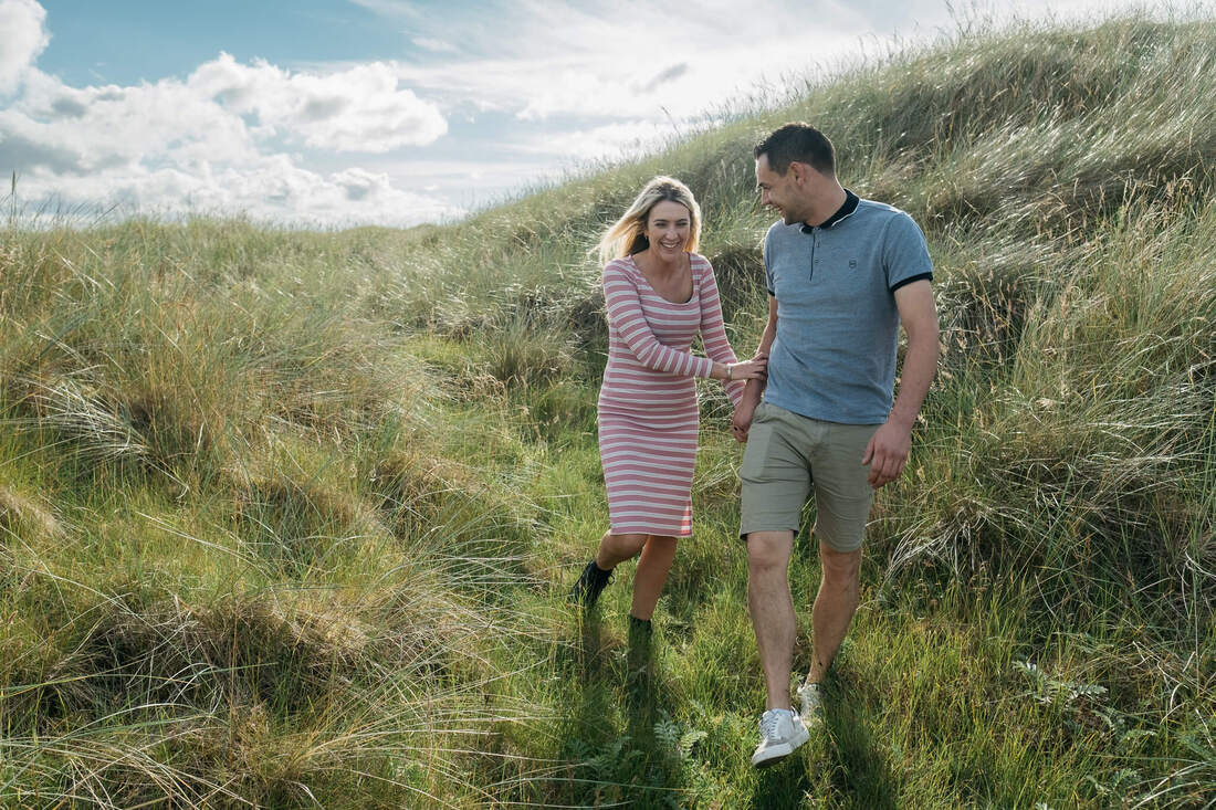 A couple walking through the long grass on the way to the beach in Donegal by Patrick Duddy Photography