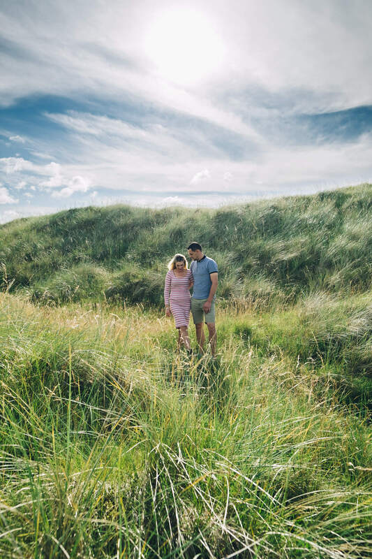 A couple walking through the long grass on the way to the beach in Donegal by Patrick Duddy Photography