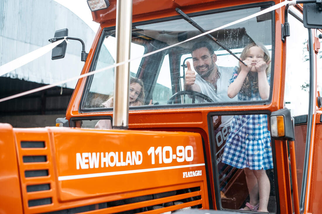 The groom and two nieces give the thumbs up from the cab of his tractor on the morning of his wedding