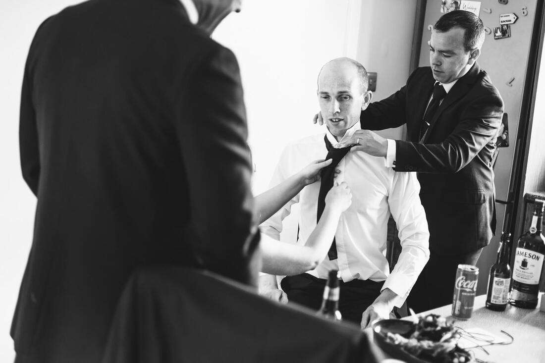 All hands on deck - the last of the groomsmen to get ready is centre getting help with his tie