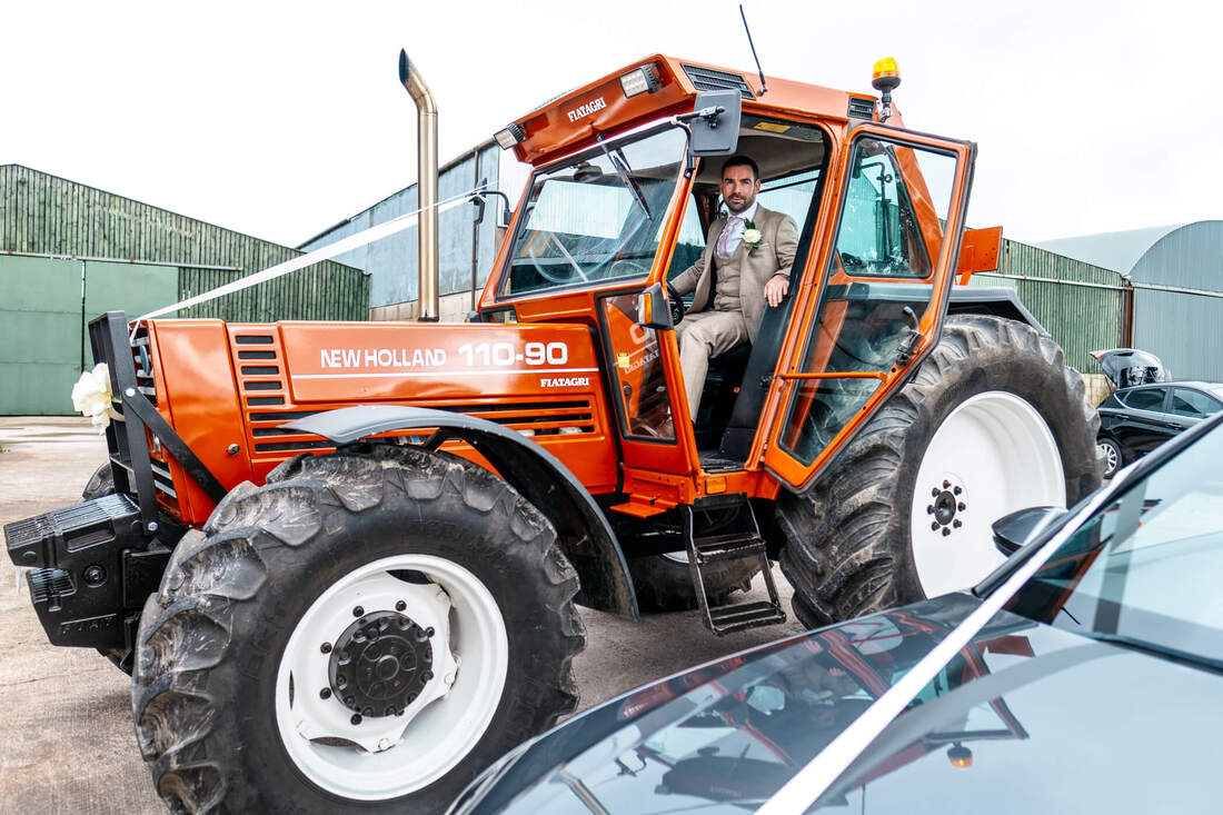 The groom, suited and booted and parking his tractor before departing for the chapel on his wedding day 