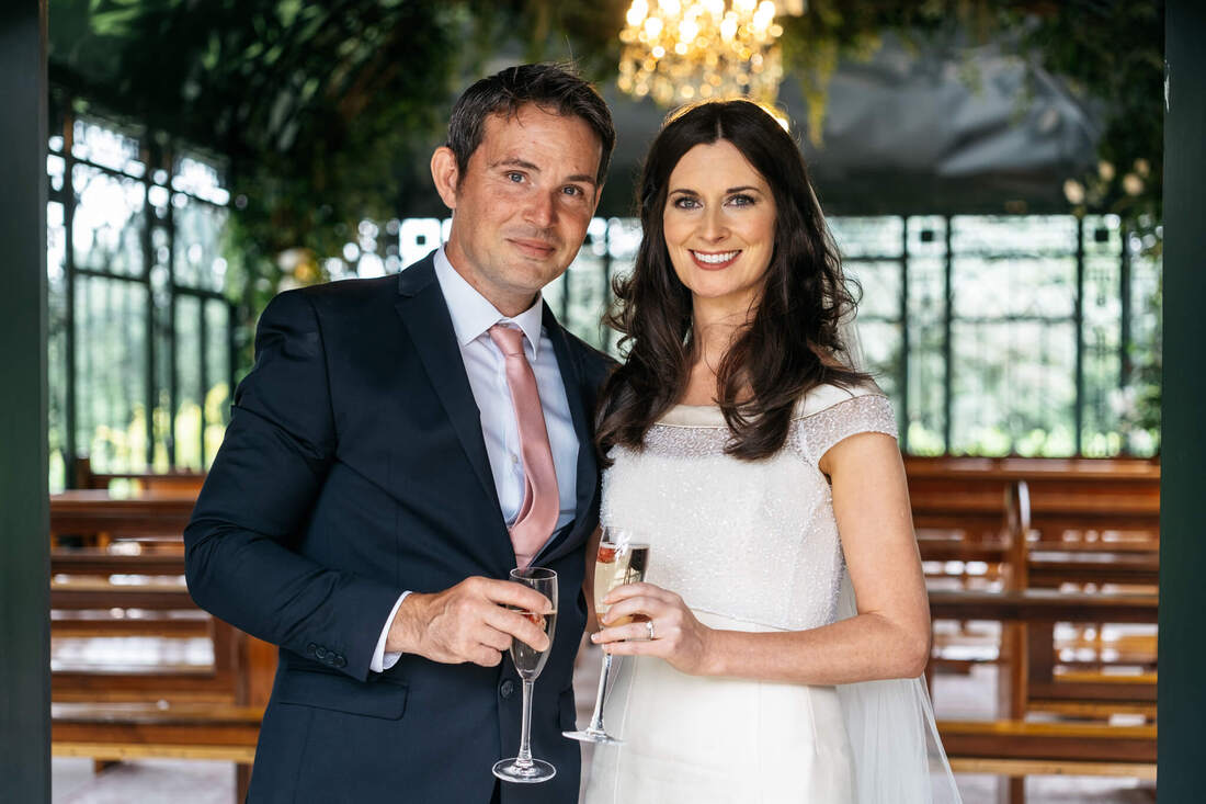 Bride and groom on their wedding days, holding two champagne flutes in the ceremony room of The Old Rectory, Killyman by Patrick Duddy Photography