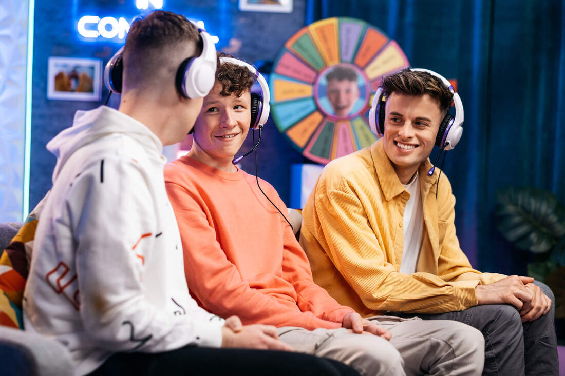 Recording of tv show for cbbc showing three friends on a sofa wearing headsets