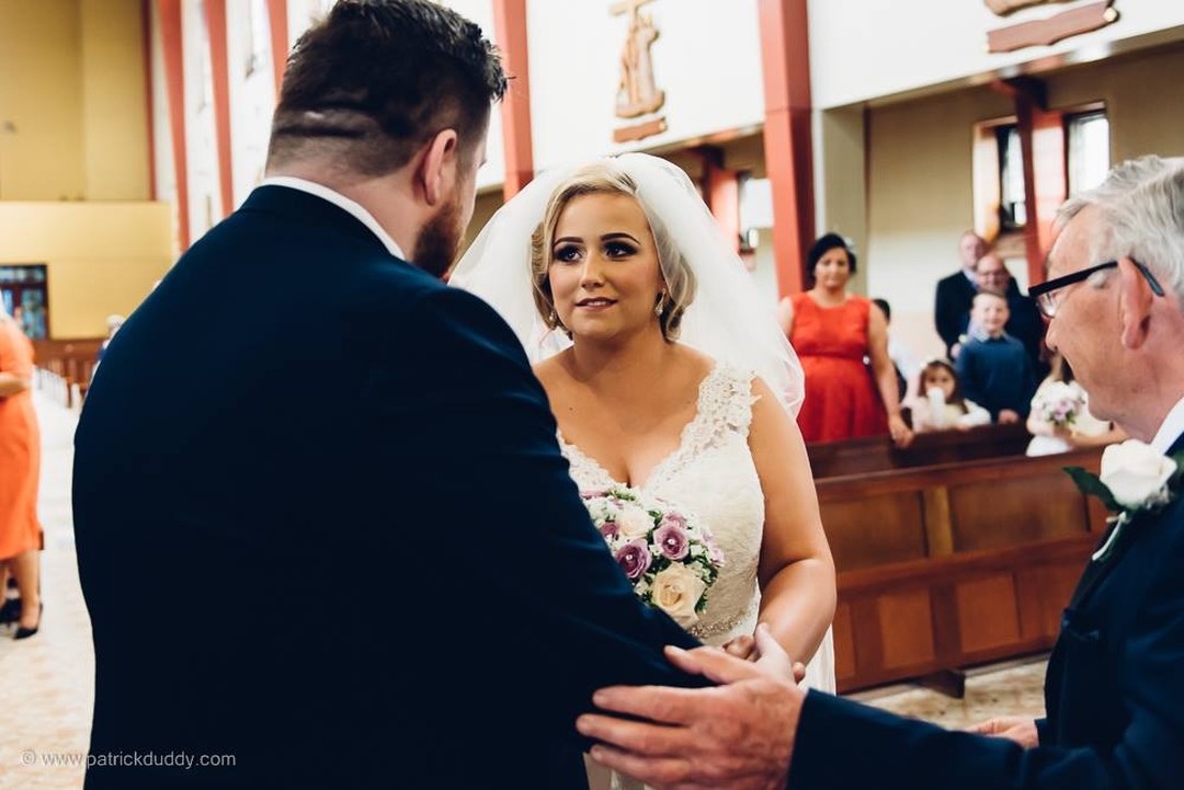 The bride gives her groom a nervous smile as they meet at the altar in St Mary's Chapel Derry