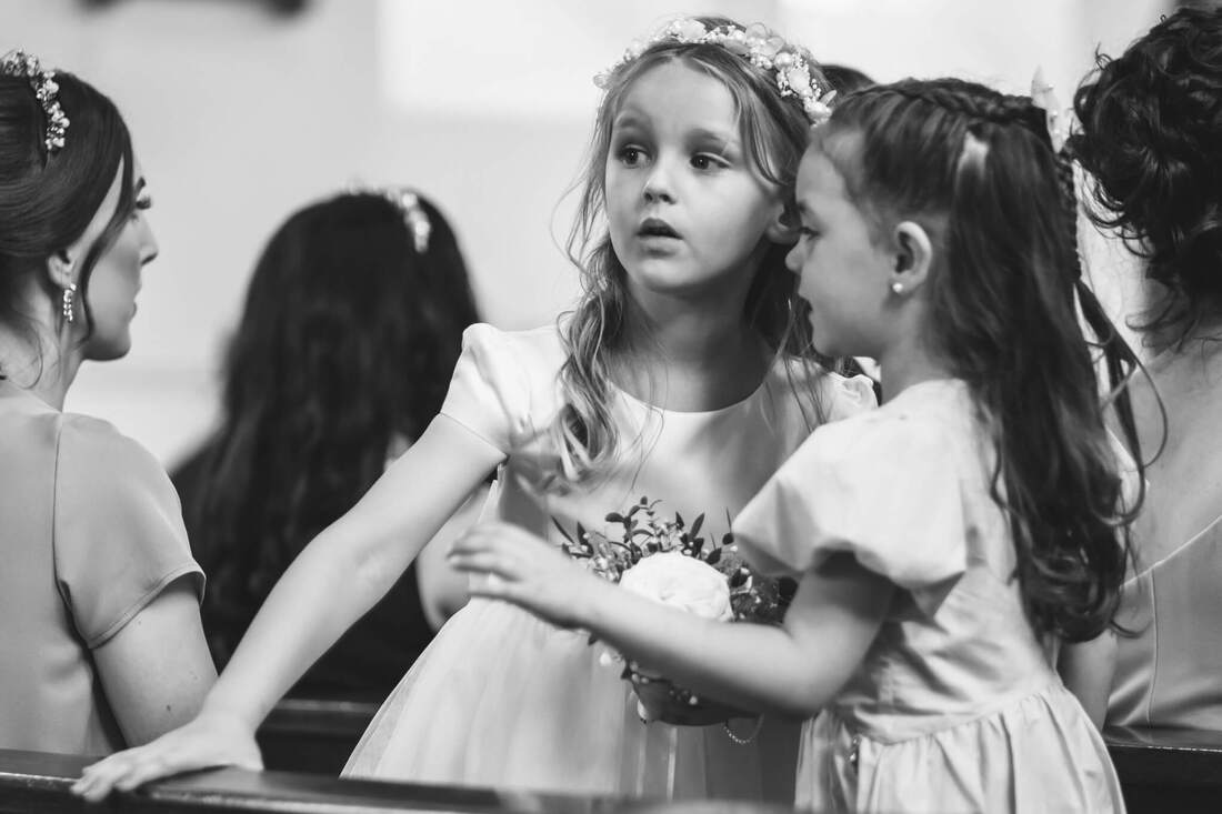 Two young girls chatting during the wedding ceremony