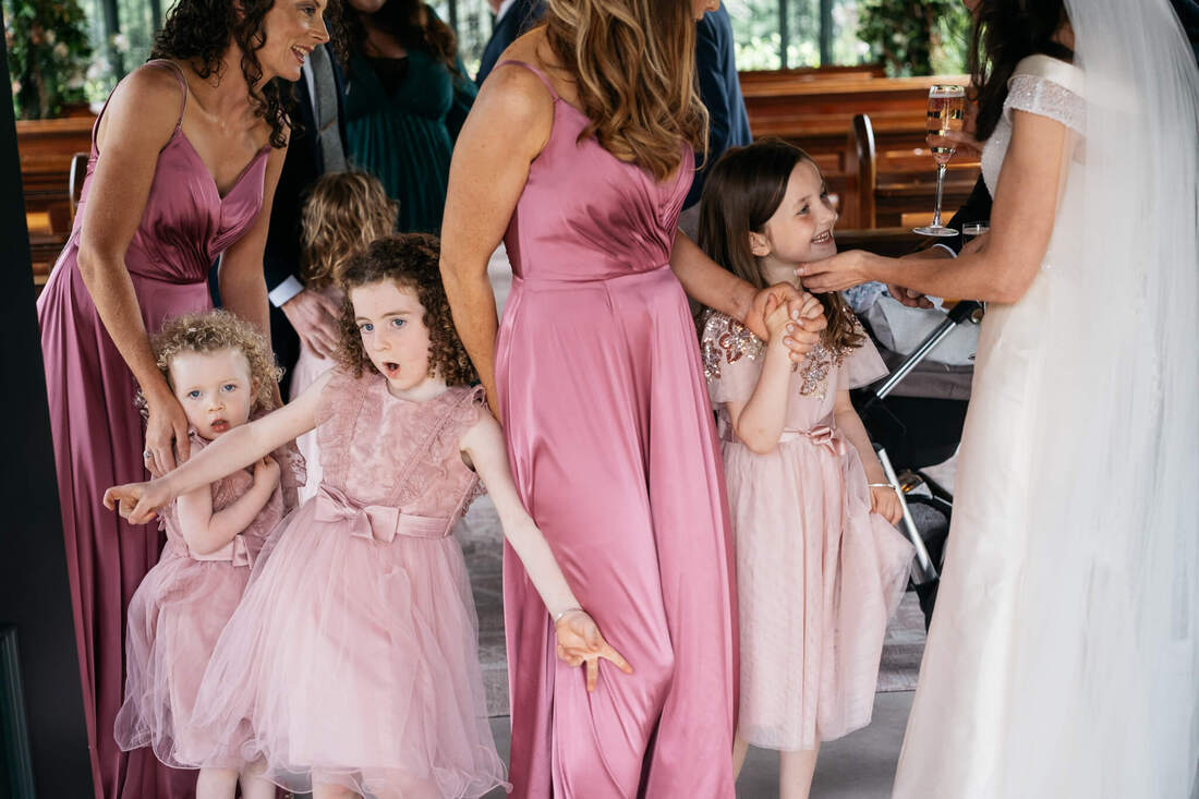 Young Flower girl's entertaining themselves while the Brides & Bridesmaids chat after the wedding