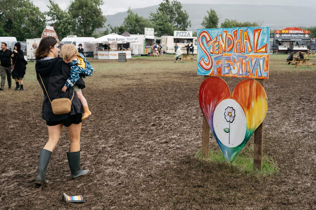 A child loses their welly boot on their way into the Stendhal Festival